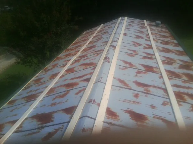 Rusted metal roof panels with new wood purlins before replacement — Storm Damage Roof Repair in Oak Park by Roofing Brothers